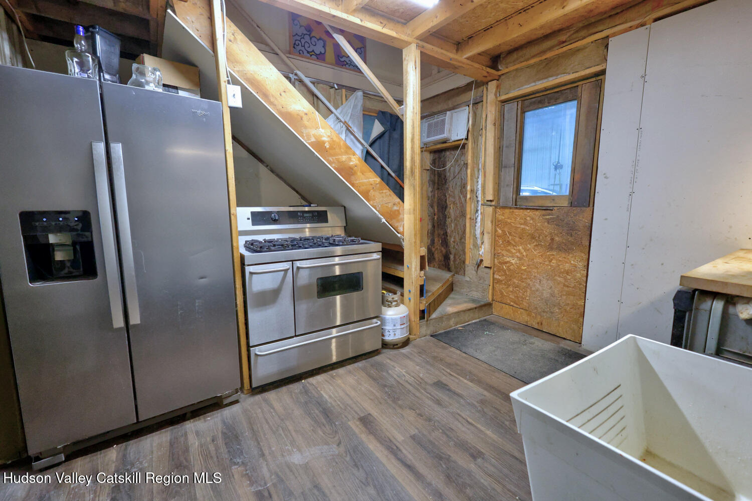 301 Sugar Loaf Road Earlton, NY 12058 - Photo 29 of 64 a view of an empty room with wooden floor and a kitchen
