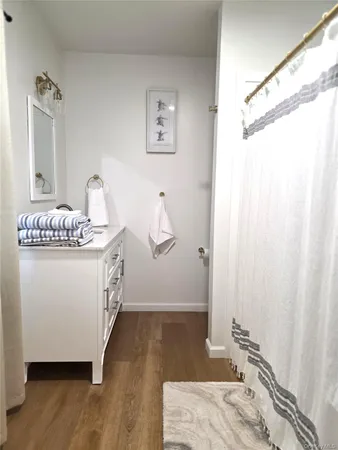 a bathroom with a granite countertop sink a mirror and shower curtain
