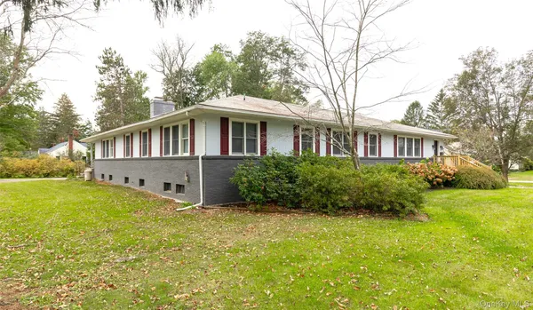 a front view of a house with yard and green space