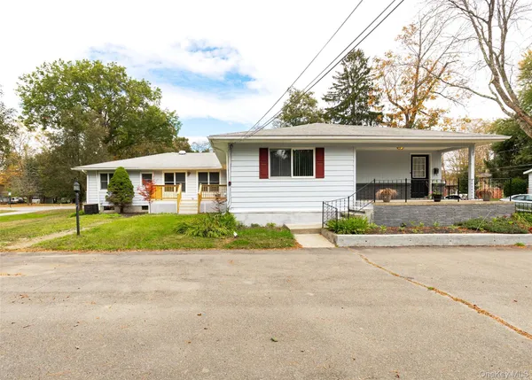 a front view of a house with a yard and potted plants
