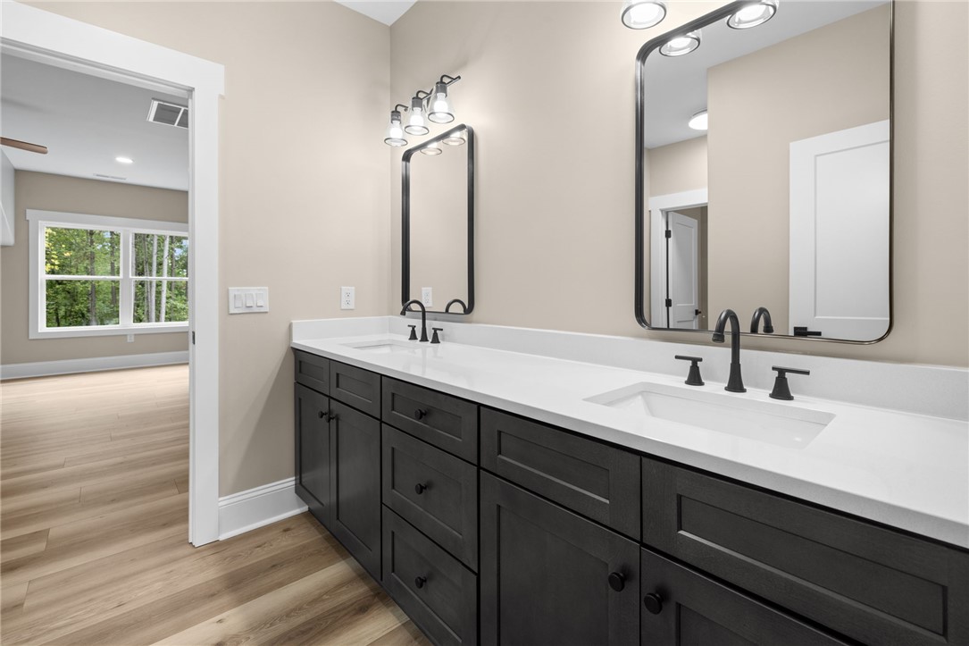 147 McAlister Road West Union, SC 29696 - Photo 37 of 50 A spacious double vanity features sleek dark cabinets and modern fixtures under crisp lighting.