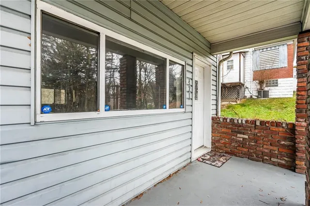 a view of a porch with wooden floor and floor to ceiling window