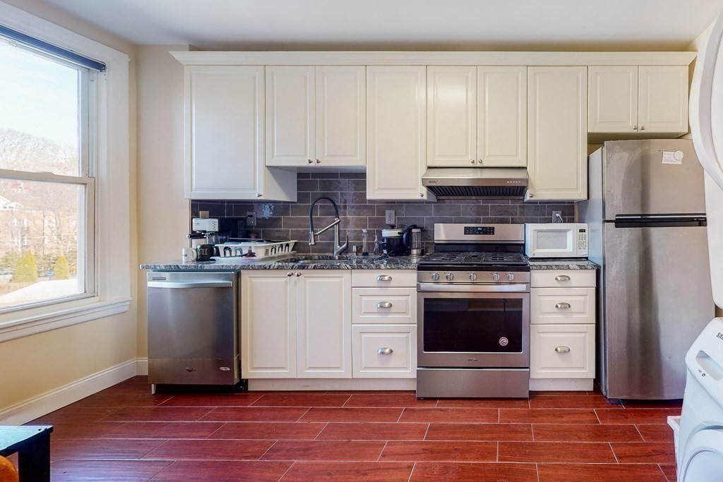 9 Wallingford Road Boston, MA 02135 - Photo 13 of 22 a kitchen with stainless steel appliances granite countertop a stove a refrigerator and a microwave