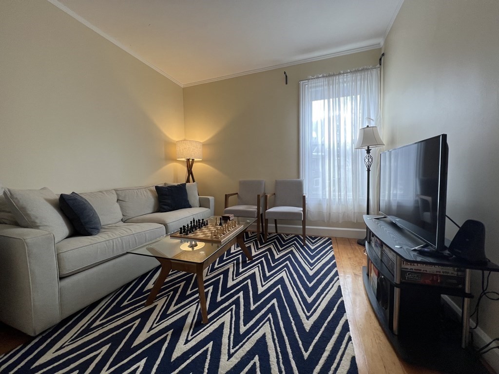 9 Wallingford Road Boston, MA 02135 - Photo 14 of 22 a living room with furniture and a flat screen tv