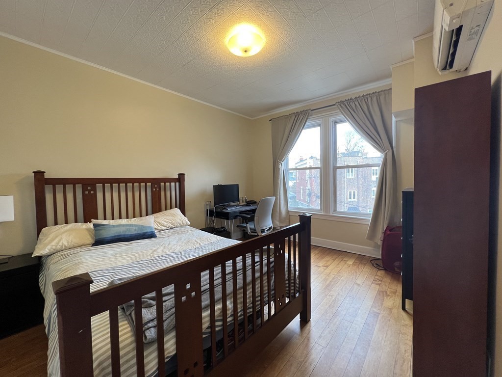 9 Wallingford Road Boston, MA 02135 - Photo 15 of 22 a bedroom with a bed and wooden floor
