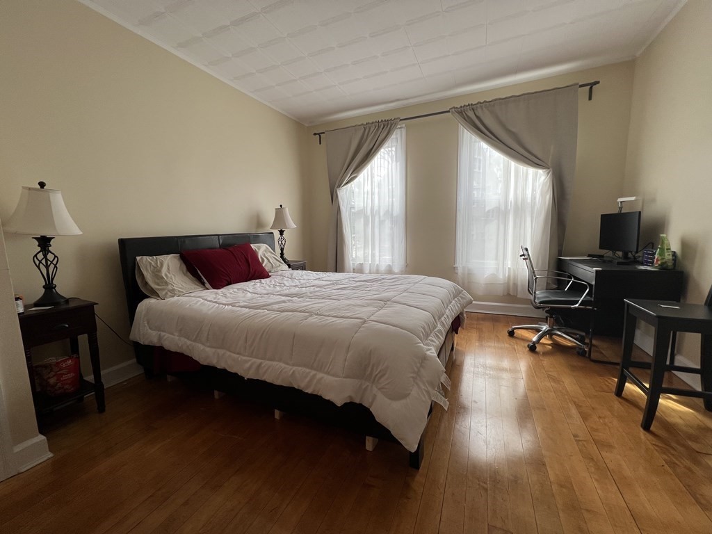 9 Wallingford Road Boston, MA 02135 - Photo 16 of 22 a bedroom with a bed a dresser next to a large window