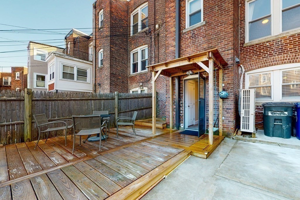 9 Wallingford Road Boston, MA 02135 - Photo 18 of 22 a view of a patio with a table and chairs and floor to ceiling window