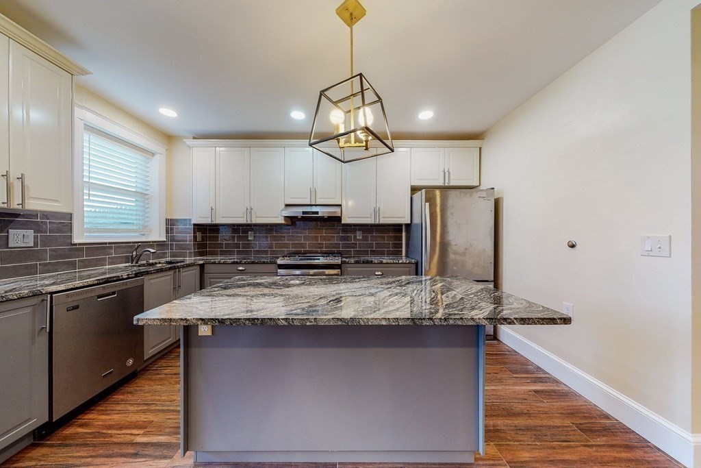 9 Wallingford Road Boston, MA 02135 - Photo 4 of 22 a kitchen with stainless steel appliances granite countertop a sink a stove a refrigerator cabinets and chairs