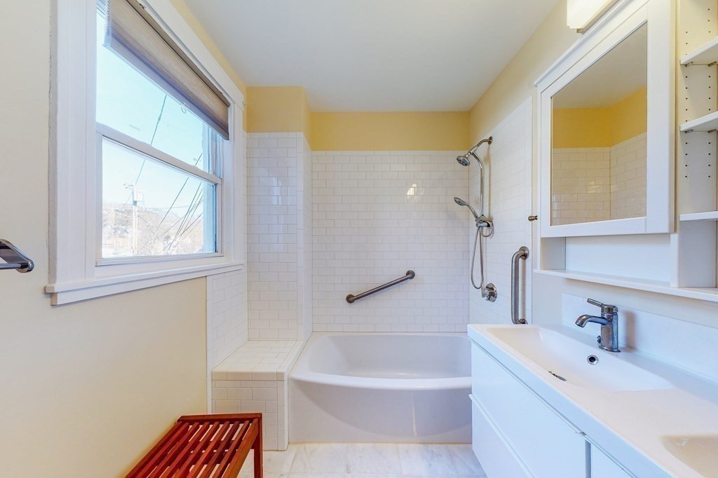 9 Wallingford Road Boston, MA 02135 - Photo 10 of 22 a bathroom with a tub a sink and a window