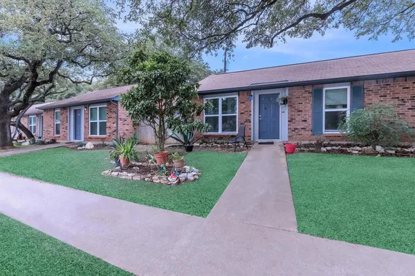a front view of a house with a garden and plants