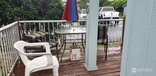 a balcony with wooden floor table and chairs