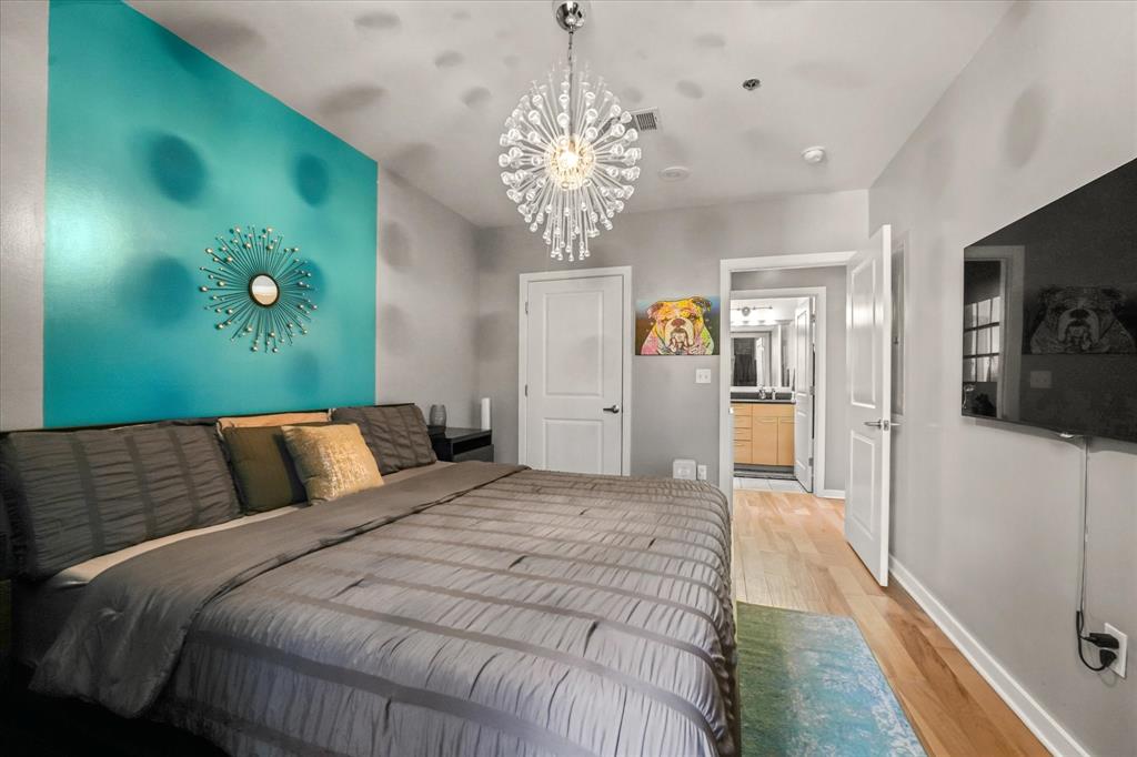 1200 Main Street, Unit 1508 Dallas, TX 75202 - Photo 15 of 16 a bedroom with a bed and a chandelier