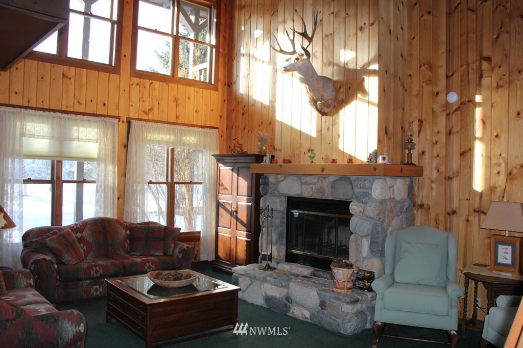 80 Tice Ranch Road Twisp, WA 98856 - Photo 8 of 22 a living room with furniture a fireplace and a large window