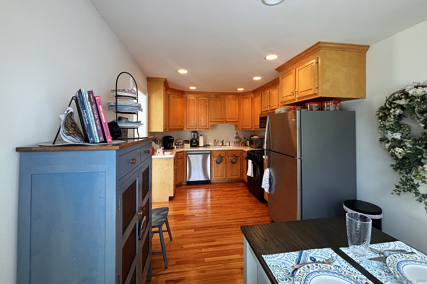 391 South Pine Creek Road Fairfield, CT 06824 - Photo 11 of 25 a kitchen with stainless steel appliances granite countertop a refrigerator a stove and a wooden floors