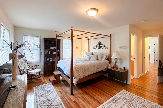 a bedroom with a bed and wooden floor