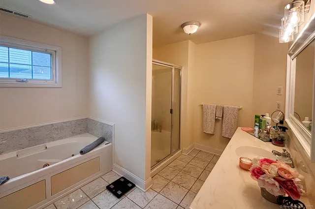 a bathroom with a tub sink and a mirror