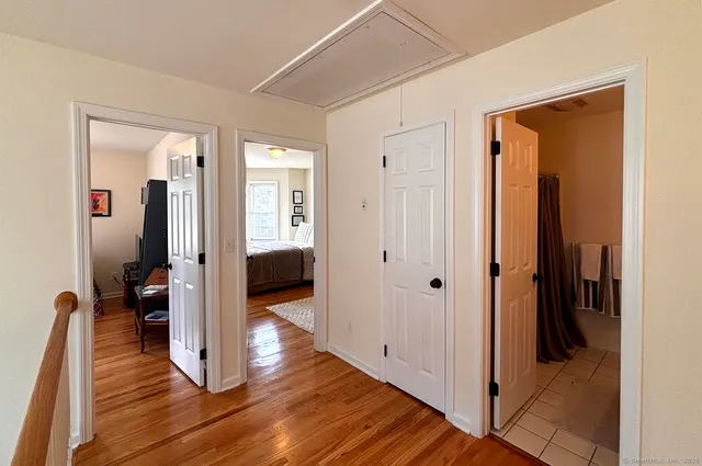 a view of a hallway with wooden floor and staircase