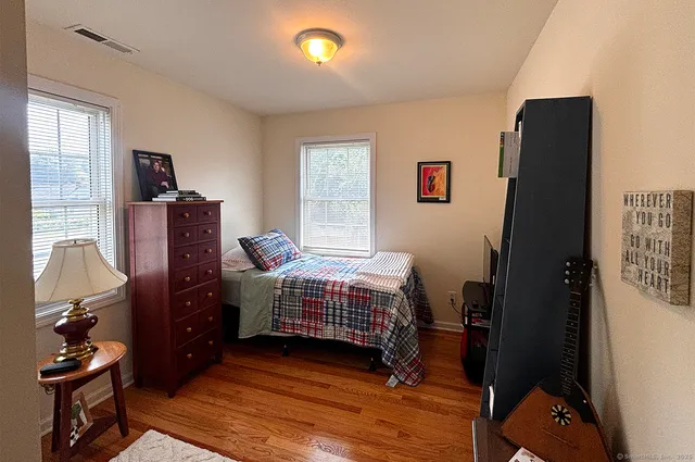 a bedroom with a bed and wooden floor