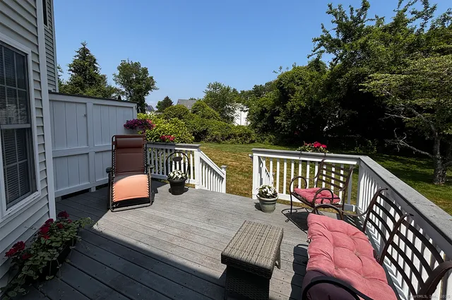 a balcony with wooden floor table and chairs