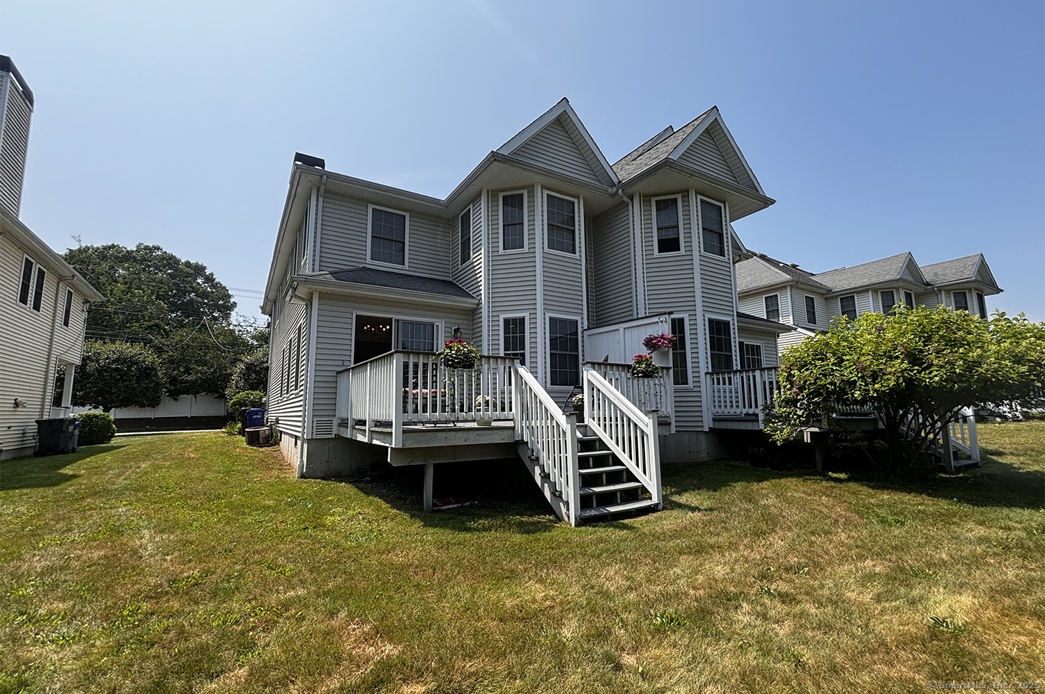 391 South Pine Creek Road Fairfield, CT 06824 - Photo 22 of 25 a front view of a house with a yard table and chairs