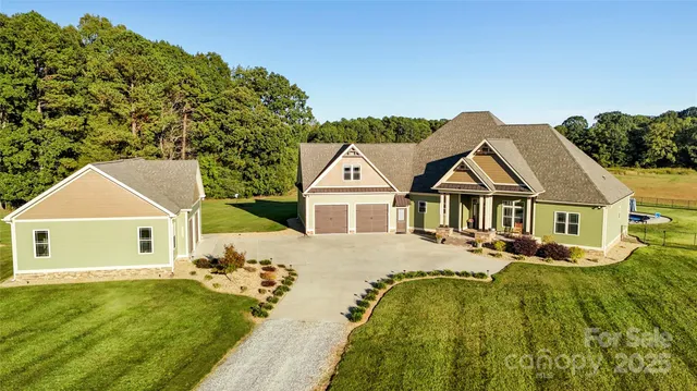 a view of a white house with a big yard and potted plants