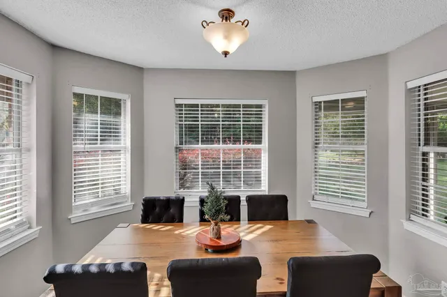 a dining room with furniture and a large window