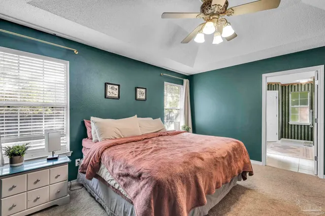 a bedroom with a large bed and a chandelier