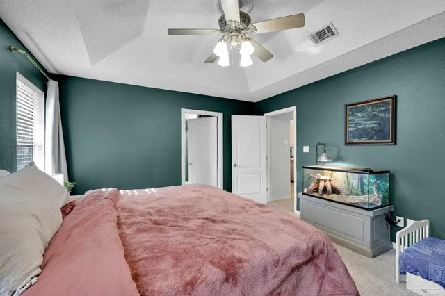 a bedroom with a bed and a ceiling fan