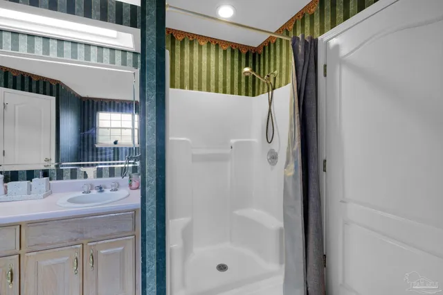 a bathroom with a shower a sink and a mirror