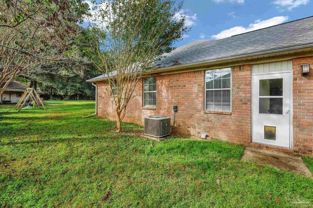 a front view of a house with a yard and trees