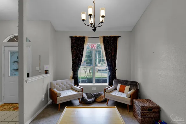 a living room with furniture chandelier and a window