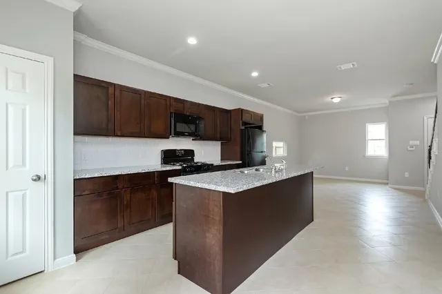 a kitchen with stainless steel appliances granite countertop a sink stove and refrigerator