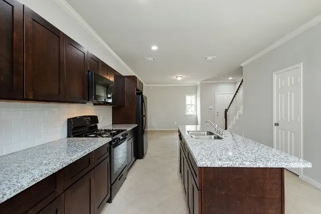 a kitchen with stainless steel appliances granite countertop a sink stove and cabinets