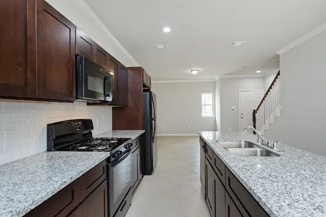 a kitchen with kitchen island stainless steel appliances a sink stove and refrigerator