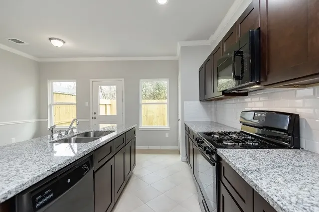 a kitchen with stainless steel appliances granite countertop a sink stove and microwave