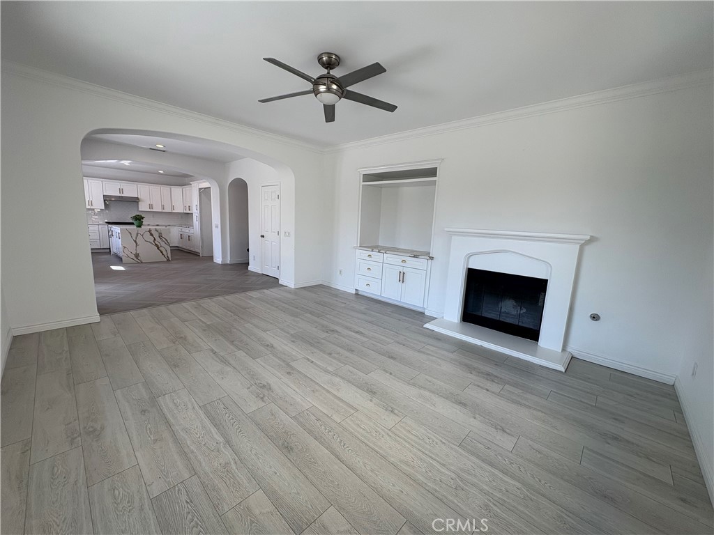 1324 Swan Loop East Upland, CA 91784 - Photo 11 of 27 a view of a livingroom with a fireplace a ceiling fan and wooden floor