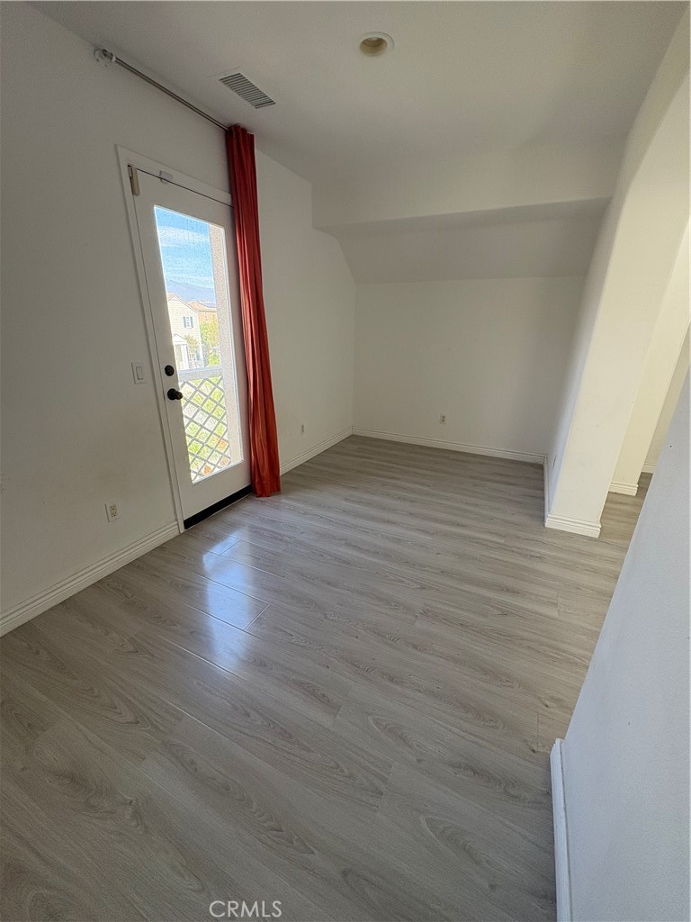 1324 Swan Loop East Upland, CA 91784 - Photo 20 of 27 a view of an empty room with wooden floor and a window