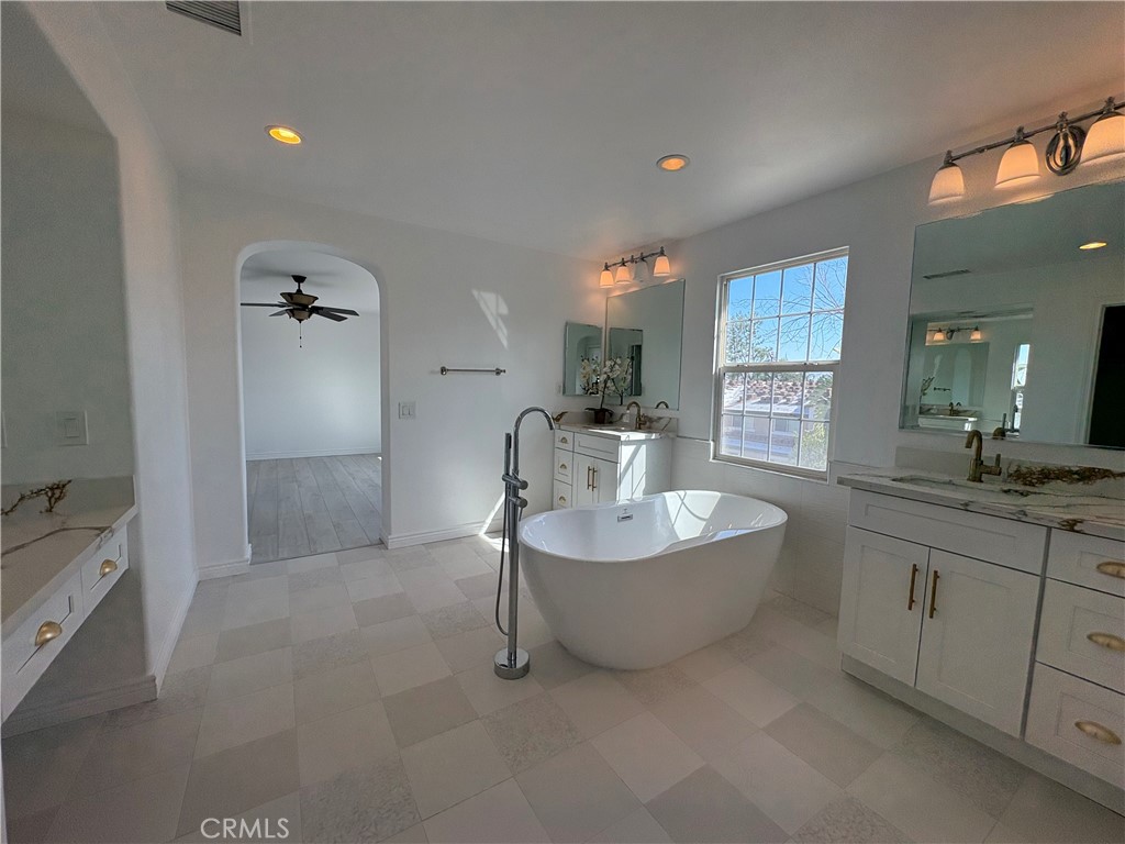 1324 Swan Loop East Upland, CA 91784 - Photo 21 of 27 a spacious bathroom with a double vanity sink a mirror and a bathtub
