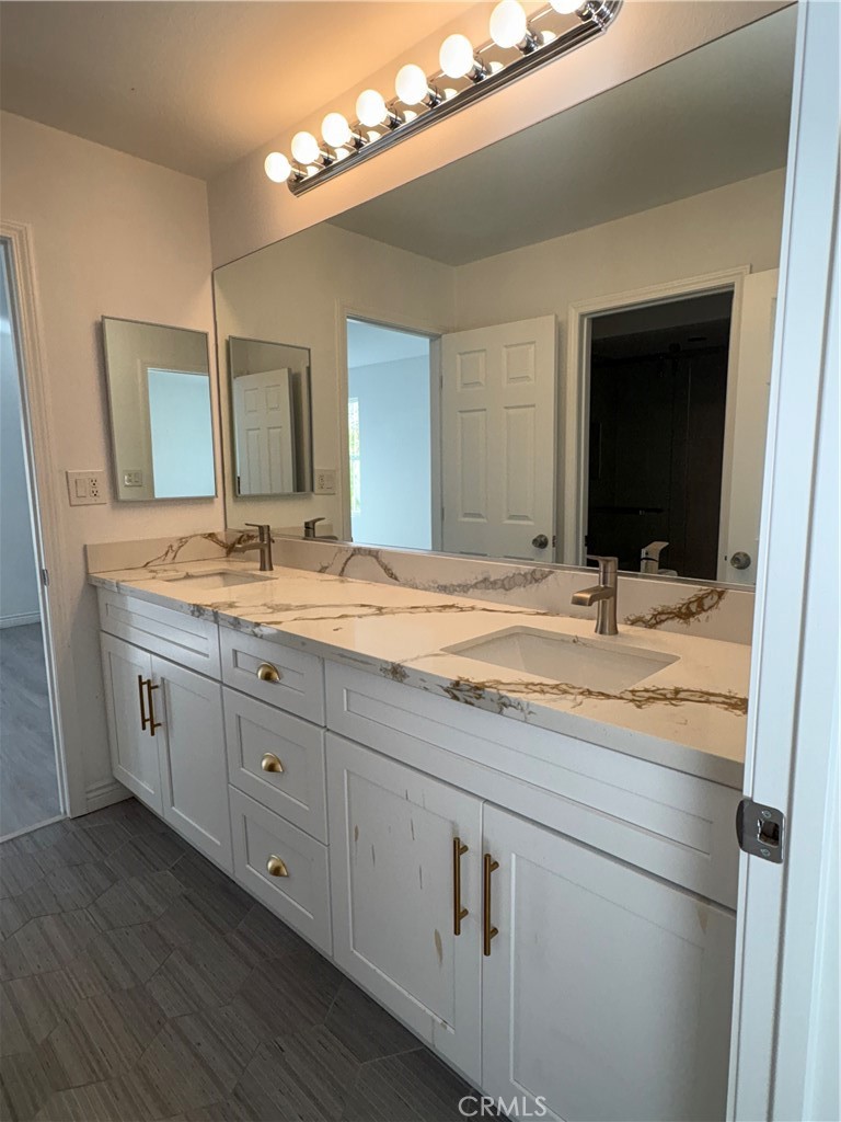 1324 Swan Loop East Upland, CA 91784 - Photo 24 of 27 a bathroom with double sink and a mirror