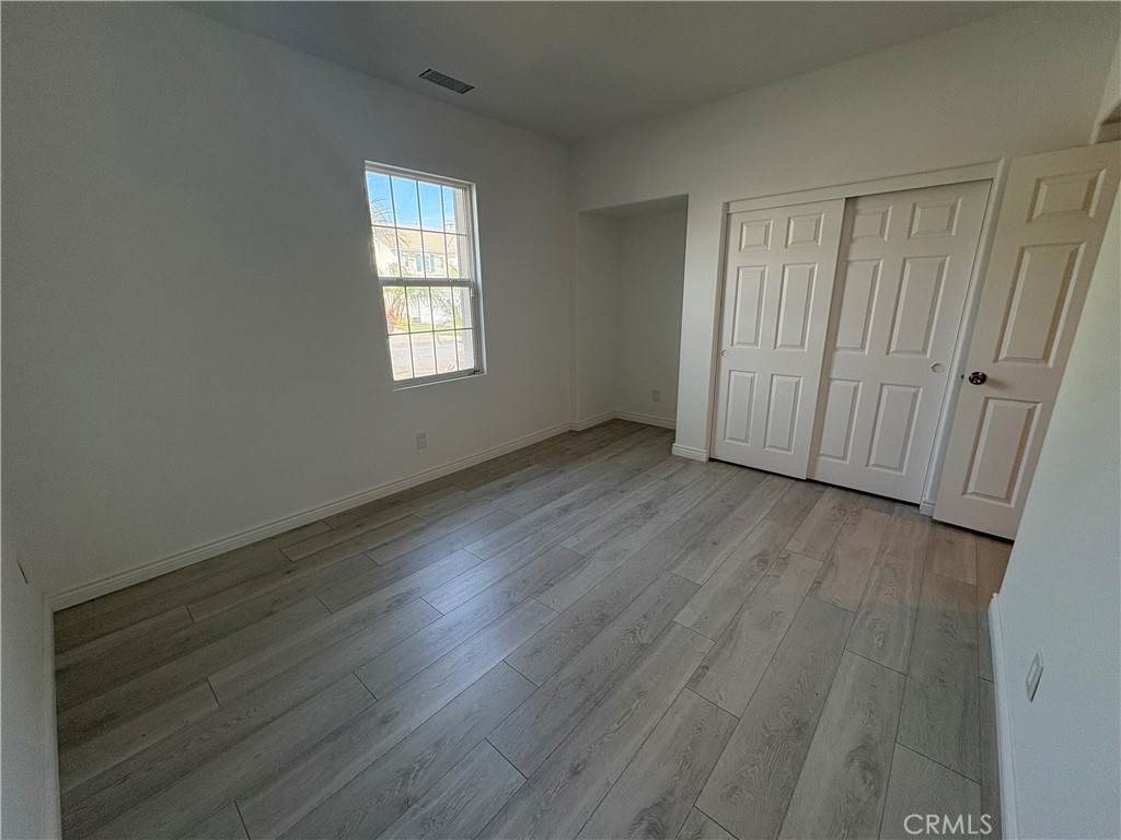 1324 Swan Loop East Upland, CA 91784 - Photo 3 of 27 an empty room with wooden floor and windows