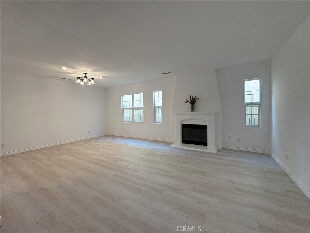 1324 Swan Loop East Upland, CA 91784 - Photo 5 of 27 a view of an empty room with chandelier and fireplace