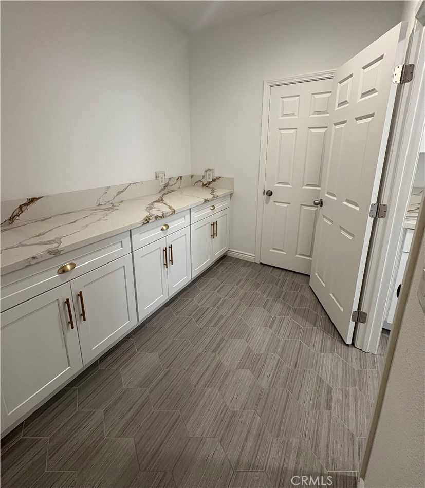 1324 Swan Loop East Upland, CA 91784 - Photo 6 of 27 a utility room with cabinets washer and dryer