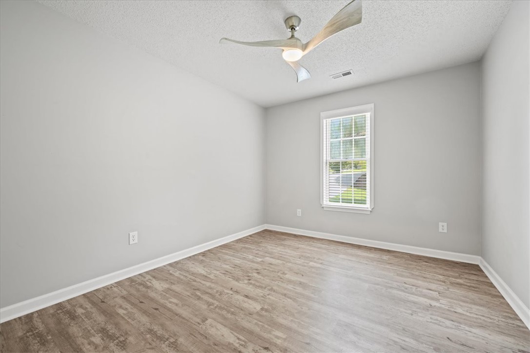212 Blue Ridge Drive Clemson, SC 29631 - Photo 20 of 33 A well-lit bedroom with modern wood-look flooring, complete with a contemporary ceiling fan for comfort.