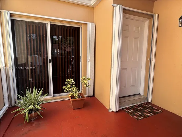 a view of a room with a potted plant and floor to ceiling window
