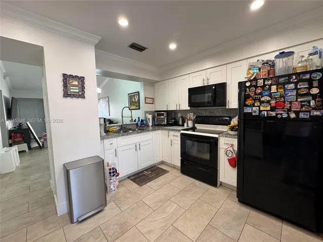 a kitchen with a refrigerator and a stove top oven