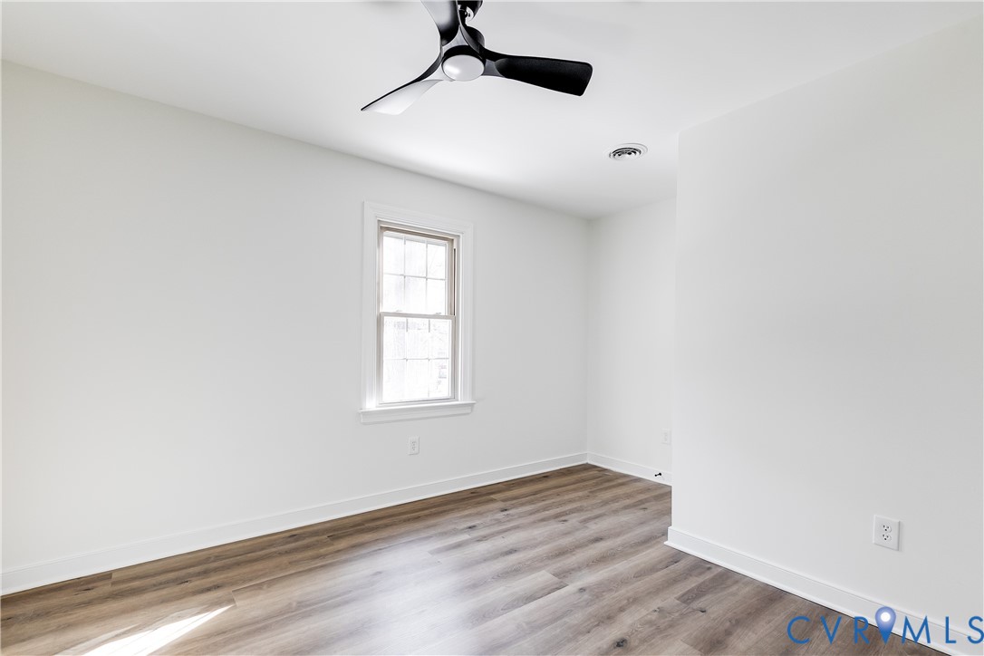 2802 Fairgate Road Midlothian, VA 23112 - Photo 28 of 38 an empty room with wooden floor a ceiling fan and windows