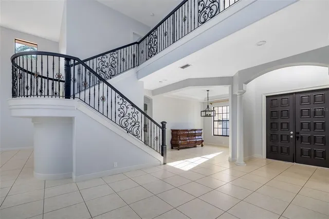 a living room with lots of white furniture and a large window