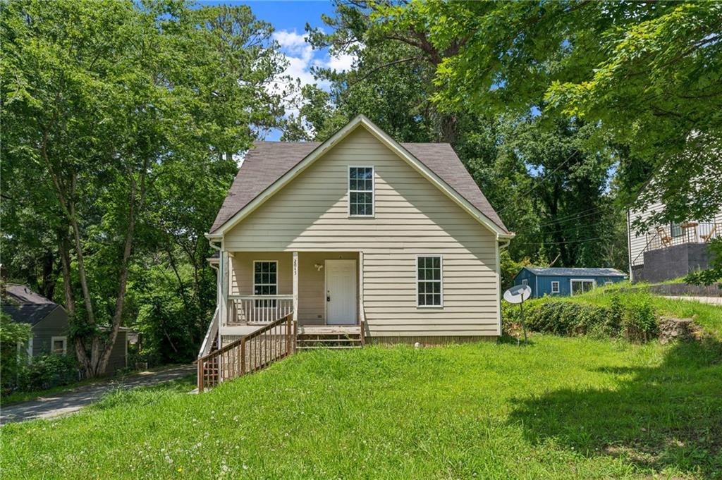 a house with green field in front of it