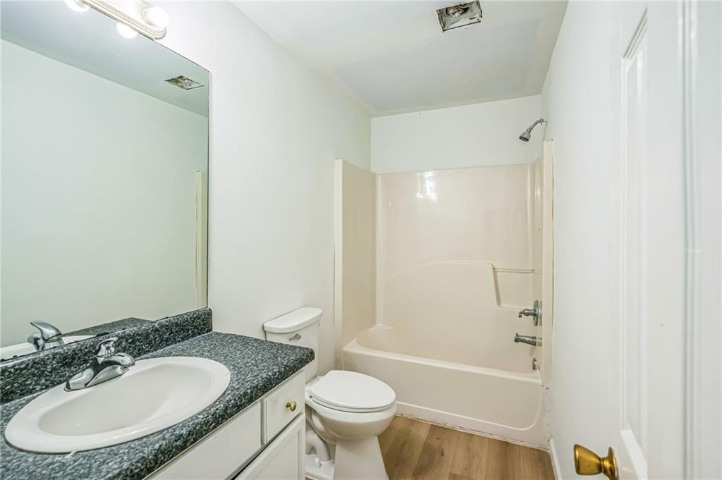 2045 Baker Road Northwest, Unit A Atlanta, GA 30318 - Photo 9 of 15 a bathroom with a granite countertop sink toilet mirror and a bathtub