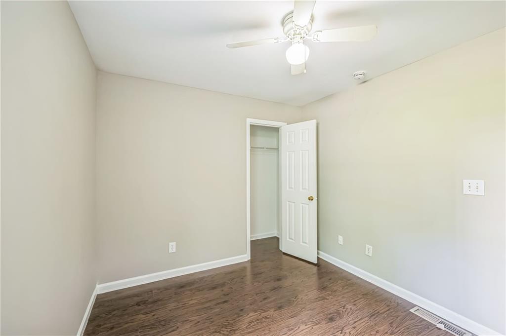 2045 Baker Road Northwest, Unit A Atlanta, GA 30318 - Photo 10 of 15 an empty room with a ceiling fan and wooden floor